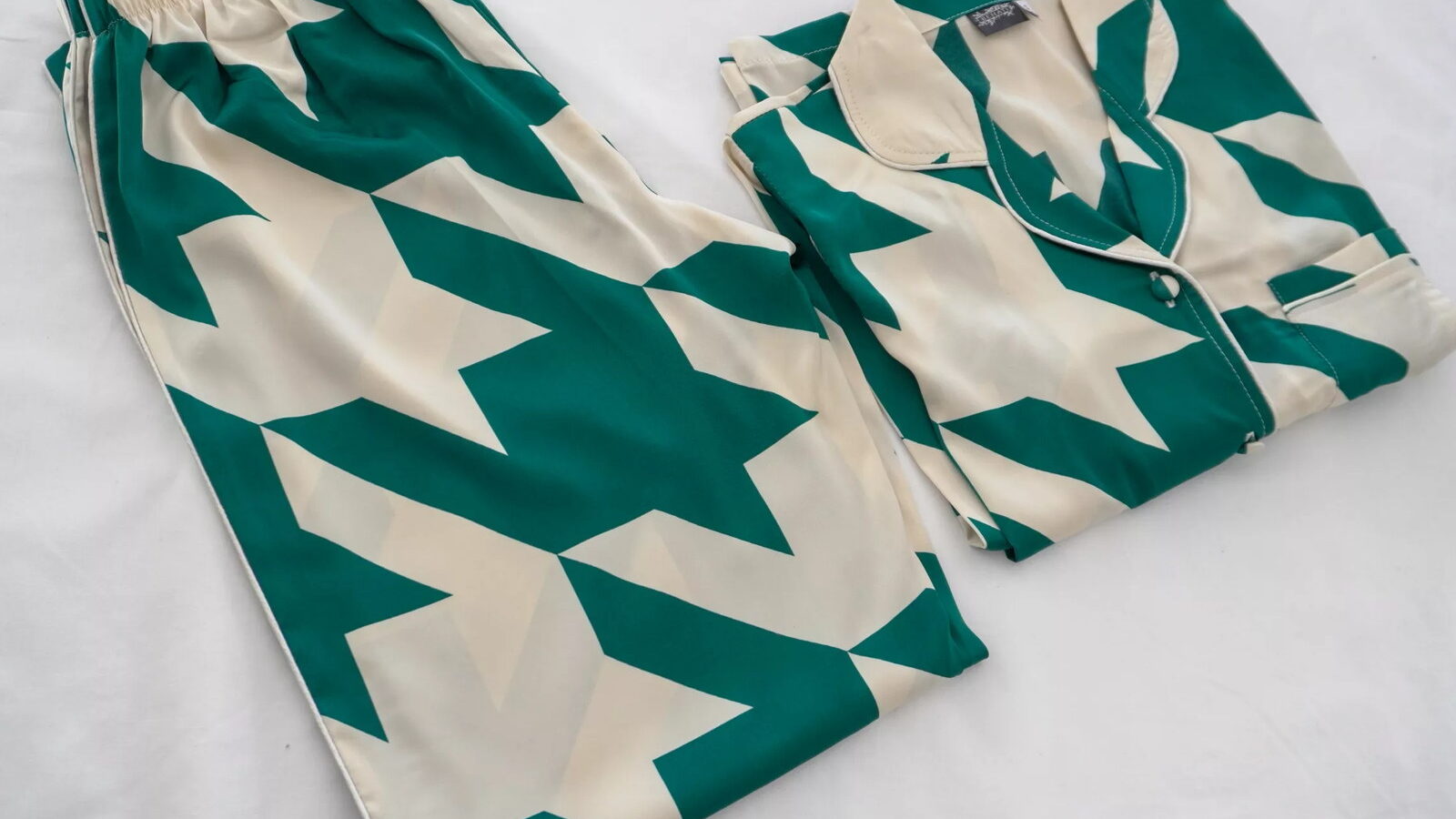 Behati satin pyjama set in green and cream houndstooth, photographed flat on white
